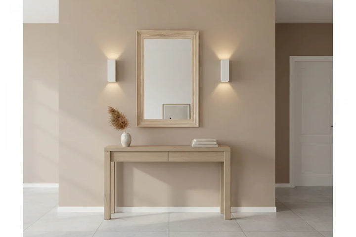 Wooden console table with mirror and decor items against a beige wall.