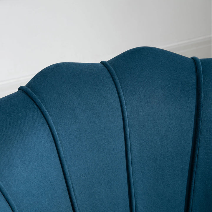 Close-up of a blue upholstered headboard against a white wall.