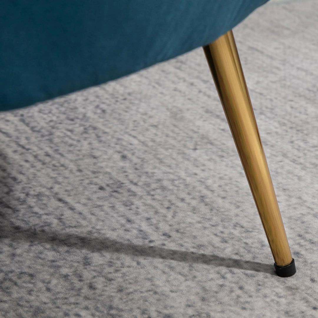 Close-up of a blue chair leg with gold finish on a gray carpet