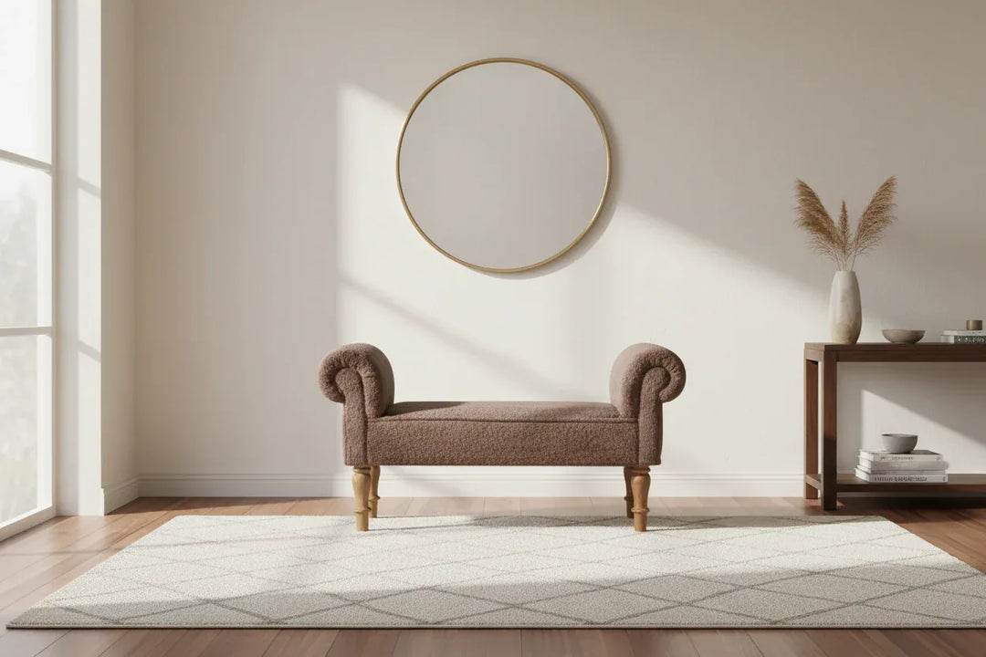 Brown upholstered bench in a room with a round mirror and wooden side table.