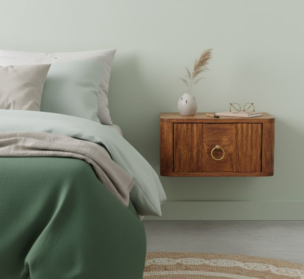 Bedroom with a wooden nightstand against a light green wall.
