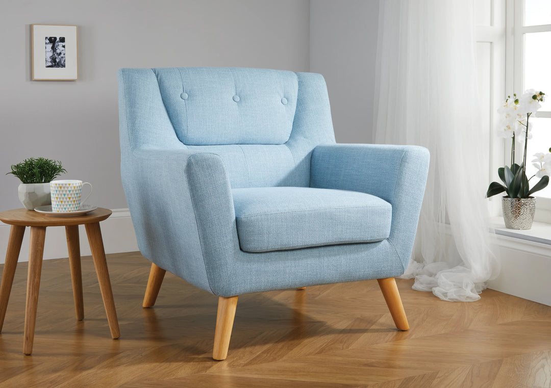 Light blue armchair in a room with wooden floor and window.
