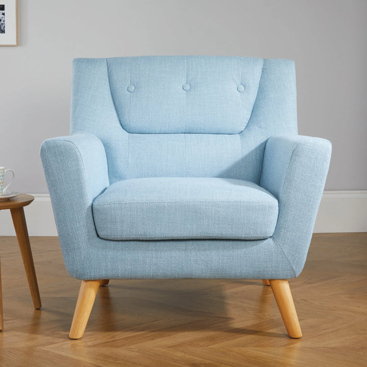 Light blue armchair in a room with wooden floor and side table.