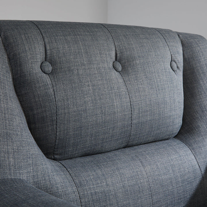 Gray upholstered chair with buttoned backrest on a plain background