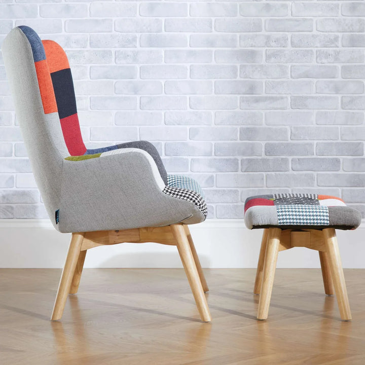 Modern chair with colorful backrest and matching ottoman against a white brick wall.
