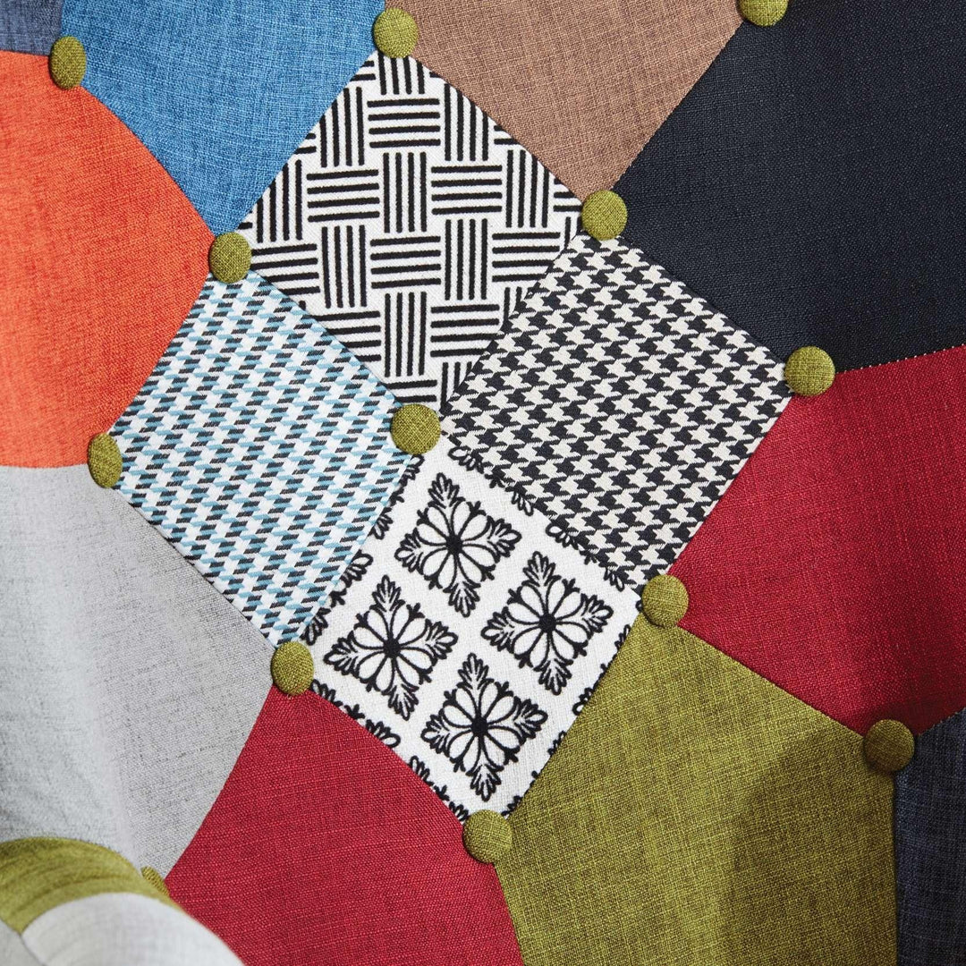 Patchwork fabric with geometric patterns and colorful buttons on a neutral background